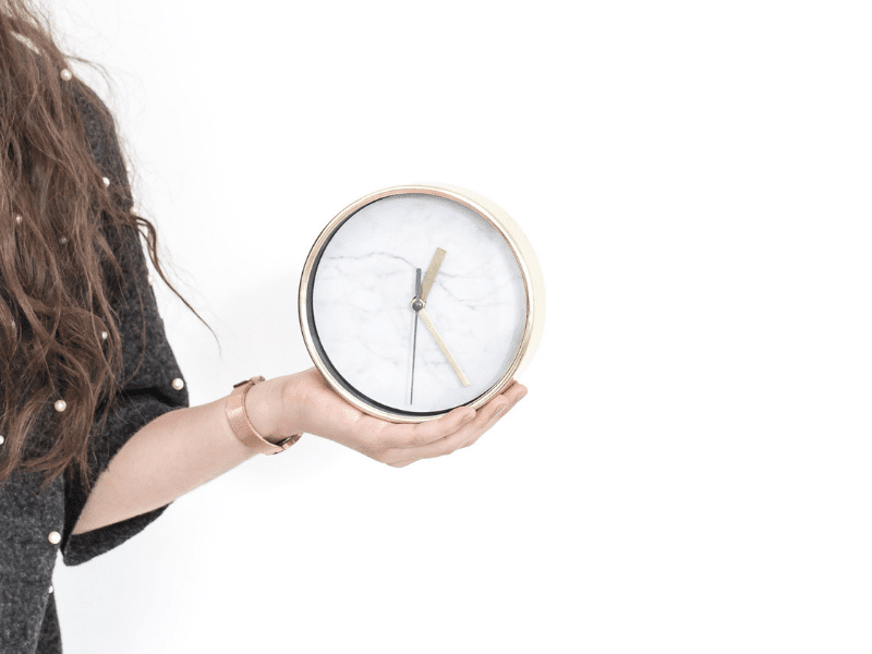 Make time for what's important, girl with a clock in her hand