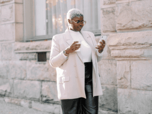 Woman looking at her phone with a coffee in her hand