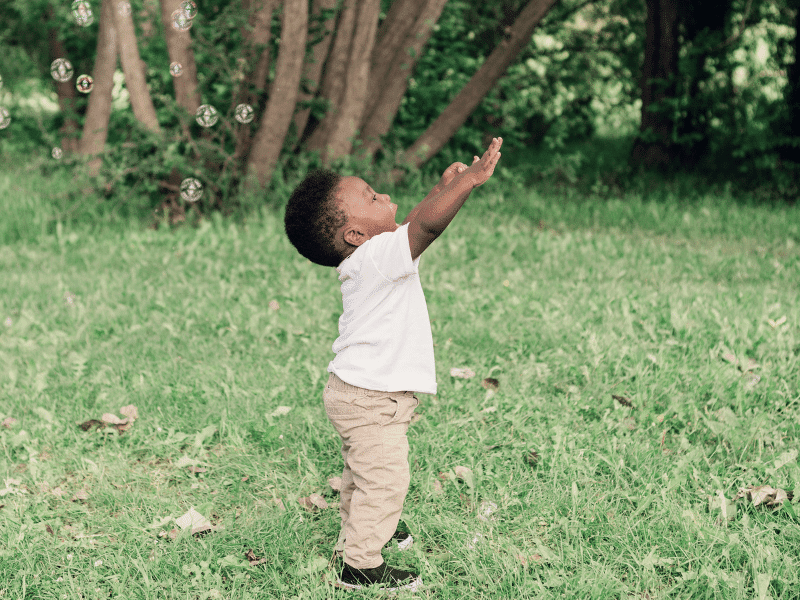 Baby playingwith bubbles outside